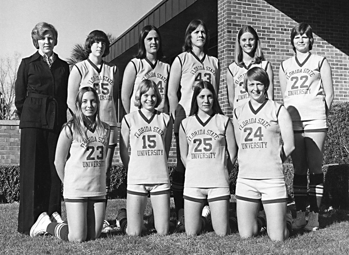 Black and white photo of Dr. Usher standing next to nine women basketball players