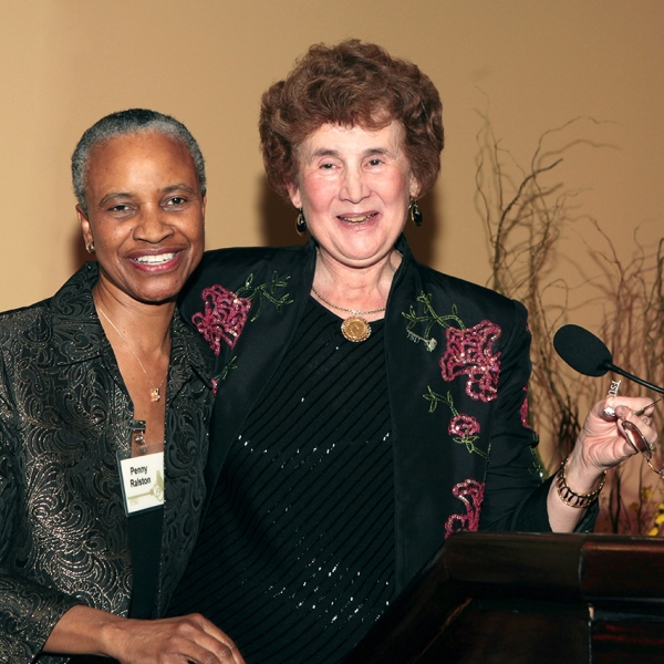 A photo of Dr. Ralston and another women, standing at a podium, smiling