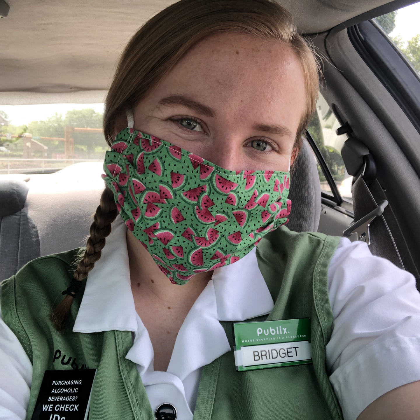 A photo of Bridget Duignan wearing a green mask with watermelons on, in a Publix uniform